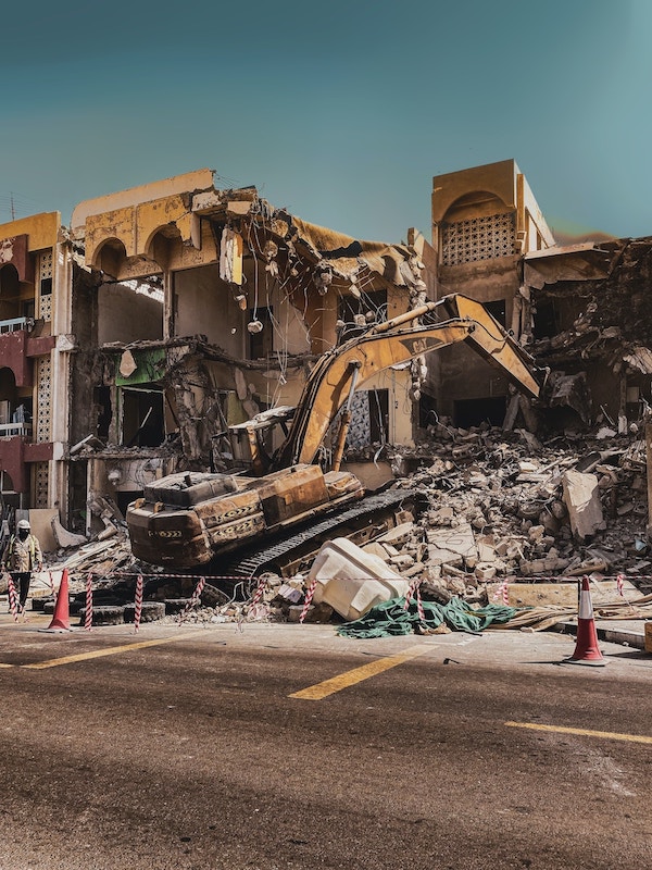 A tracked excavator tearing down a building.